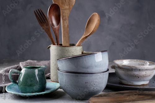 Collection of  natural  rustic  handmade crockery tableware in neutral tones on grey background