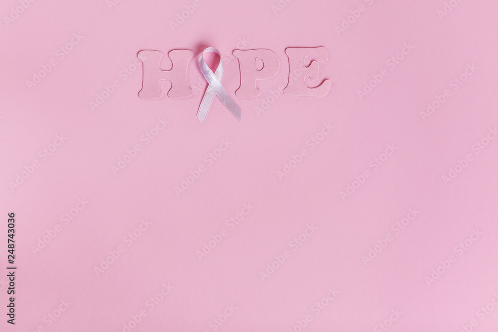 Lilac ribbon with word Hope on pink background Lilac ribbon with word Hope on pink background