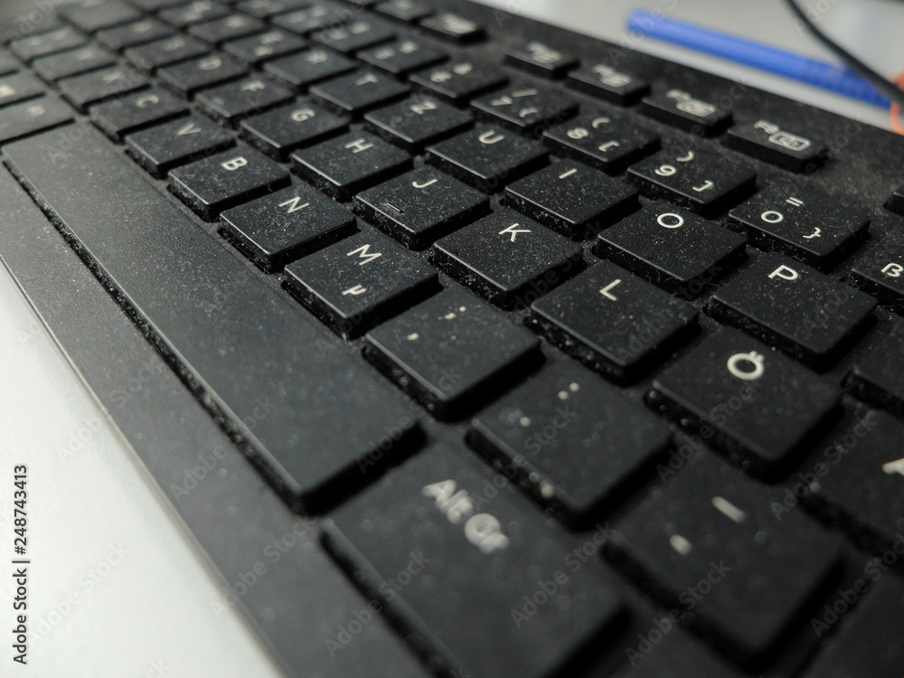 Closeup of the black dusty keyboard with German layout