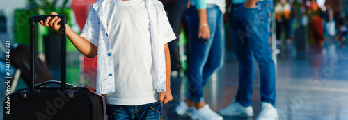 Cute little boy with suitcase at airport photo