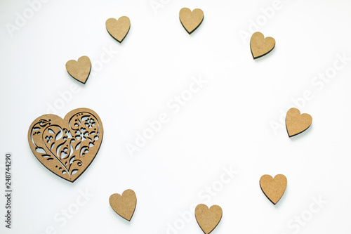 Round frame of wooden hearts on white background with copy space. Concept of spring, love, feelings, lightness, tenderness.