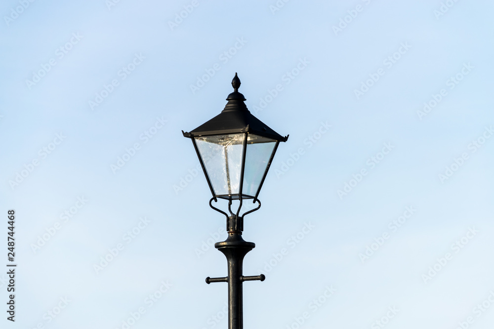 old street lamp on blue sky background