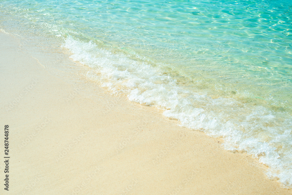 Soft wave of blue ocean on sandy beach. Background.