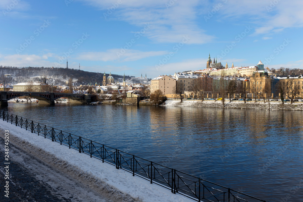 Snowy Prague Lesser Town with Prague Castle above River Vltava in the sunny Day, Czech republic