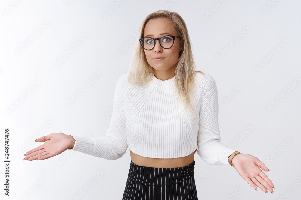 Oops I had no idea. Portrait of silly and clumsy young female blond in  glasses and cropped sexy sweater shrugging folding lips and spread hands  sideways, sorry gesture apologizing for mistake foto