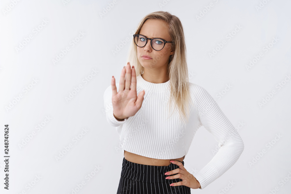 Stop right there. Upset displeased serious-looking powerful fai-haired businesswoman in glasses and trendy outfit pulling palm towards camera in forbidden and no gesture frowning dissatisfied Stop right there. Upset displeased serious-looking powerful fai-haired businesswoman in glasses and trendy outfit pulling palm towards camera in forbidden and no gesture frowning dissatisfied