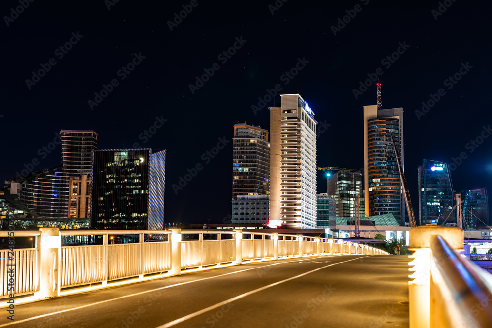 Crossing the bridge against the background of lighting skyscrapers