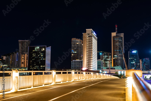 Crossing the bridge against the background of lighting skyscrapers photo