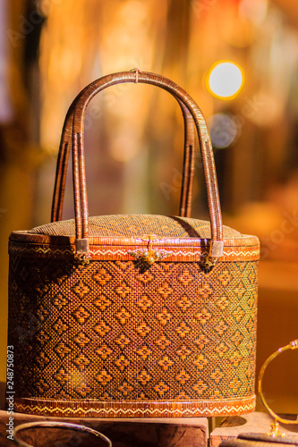 Beautiful lady handbags and basketry that made from Lygodium (climbing fern), or "Yan lipao" in Thai, the famous product from Southern Thailand for sale at night market, Bangkok. Night shot with grain