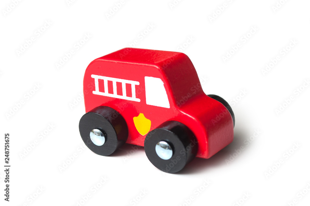 Naklejka premium closeup of red miniature wooden truck on white background - concept fire rescue
