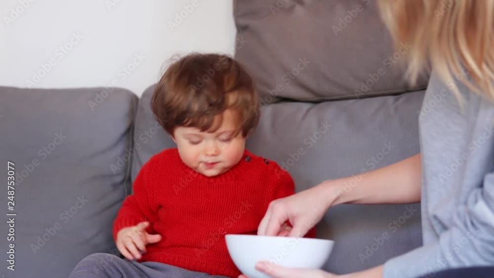 Funny little boy sitting on a sofa in red sweater. Side view Funny little boy sitting on a sofa in red sweater. Side view