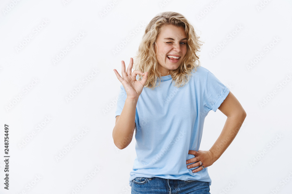 No problem, count on me. Cute and girly young female with blond short hairstyle winking joyfully, smiling and sticking out tongue as showing ok sign in no worries gesture, approve and assure No problem, count on me. Cute and girly young female with blond short hairstyle winking joyfully, smiling and sticking out tongue as showing ok sign in no worries gesture, approve and assure