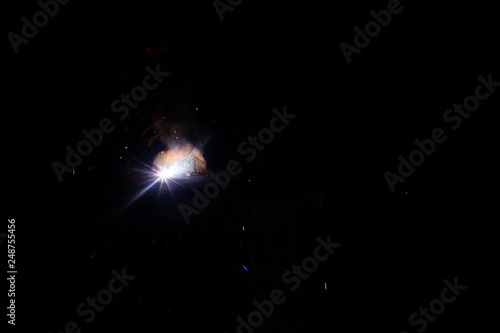 A worker man with protective mask welding metal