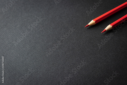 several red pencils on a black background