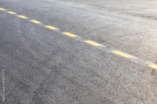 Paved surface with yellow dotted lines.