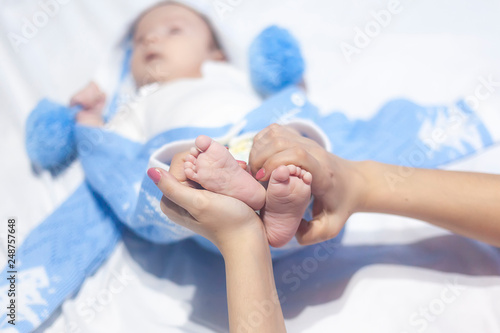 Mother holding the legs of a newborn baby boy