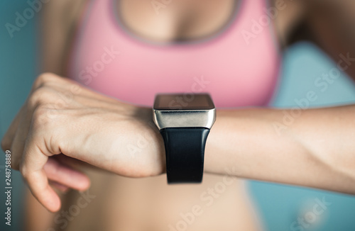 young fit female checking her smartwatch 