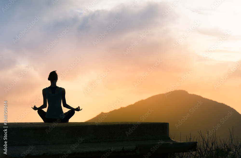 Peaceful meditation on a mountain at sunset Peaceful meditation on a mountain at sunset