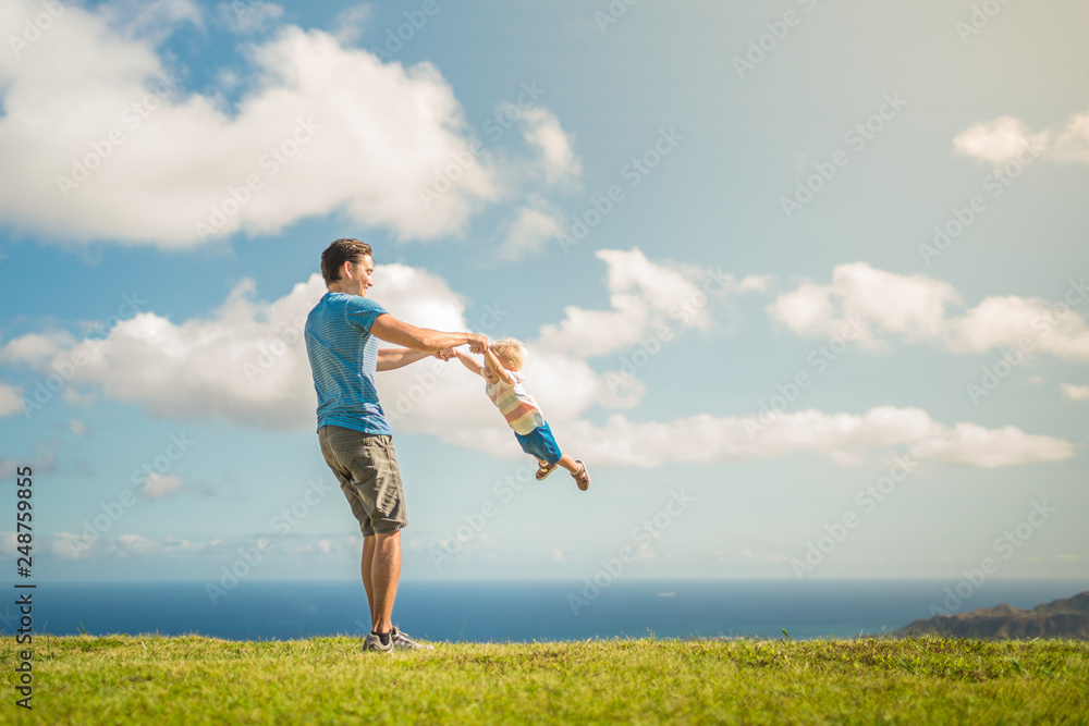 Happy father and son playing in the park 