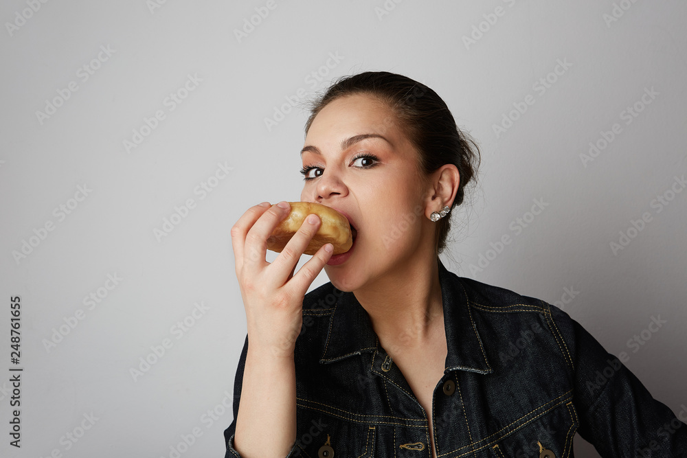 Portrait of a satisfied handsome young woman eating donuts isolated over white background Portrait of a satisfied handsome young woman eating donuts isolated over white background