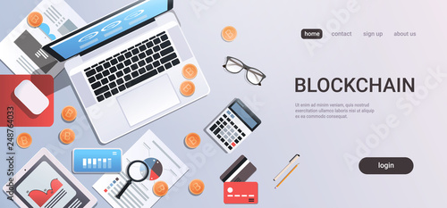 crypto currency block chain concept bitcoin mining workplace desk top angle view tablet laptop computer paper documents report finance graph flat copy space horizontal