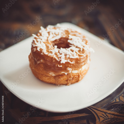 Coconut Maple Cronut on a white plate.