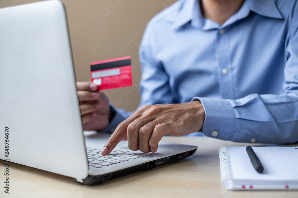 Businessman holding credit card for online shopping while making orders via the Internet. business, technology, ecommerce and online payment concept Businessman holding credit card for online shopping while making orders via the Internet. business, technology, ecommerce and online payment concept