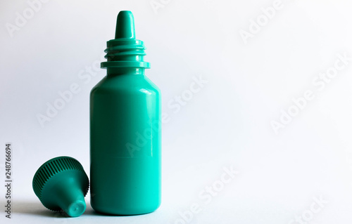 Green plastic eye dropper bottle isolated on white background.