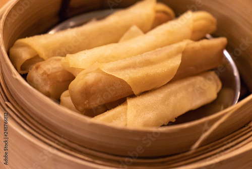 Fried Chinese spring rolls in the wooden basket.