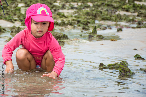 Fototapeta Naklejka Na Ścianę i Meble -  Criança brincando com areia na praia 