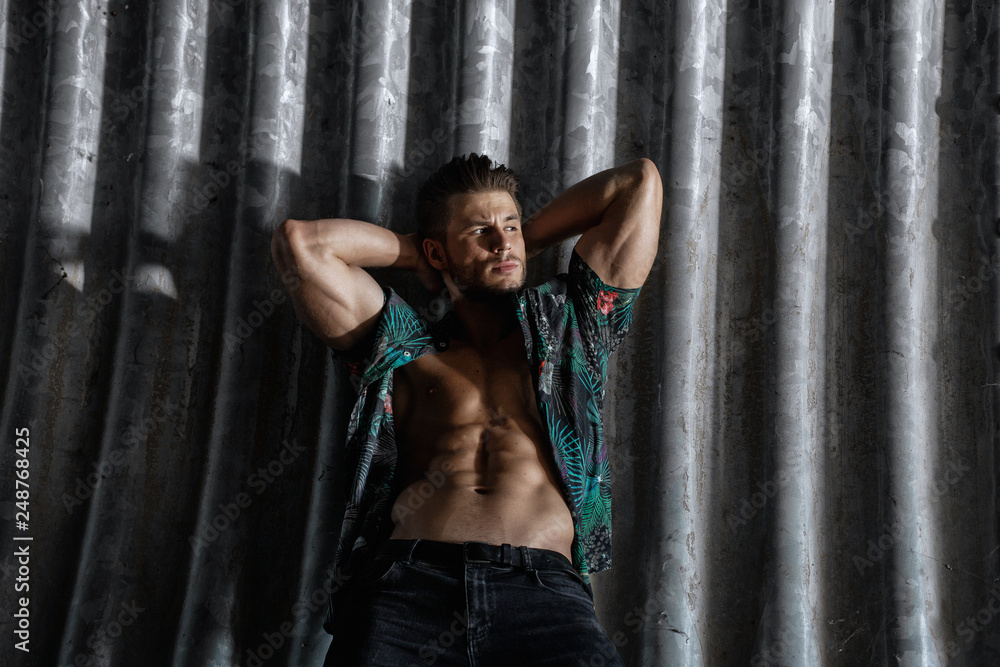 Muscular young man with beard on dark tunnel urban background. Fashion portrait of brutal strong muscle guy with modern trendy hairstyle. Model, fashion concept. Sexy naked torso, six pack abs. Muscular young man with beard on dark tunnel urban background. Fashion portrait of brutal strong muscle guy with modern trendy hairstyle. Model, fashion concept. Sexy naked torso, six pack abs.