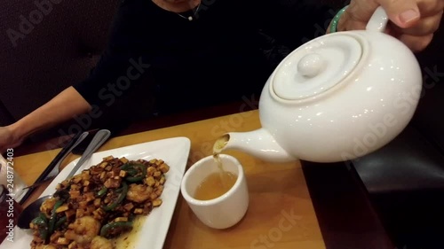 Pouring Hot Tea while eating Chinese food.