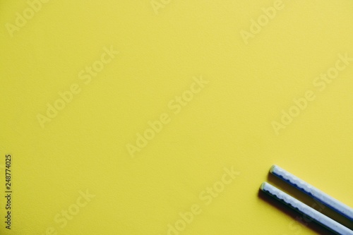 Plastic Blue chopsticks On Yellow Background close up