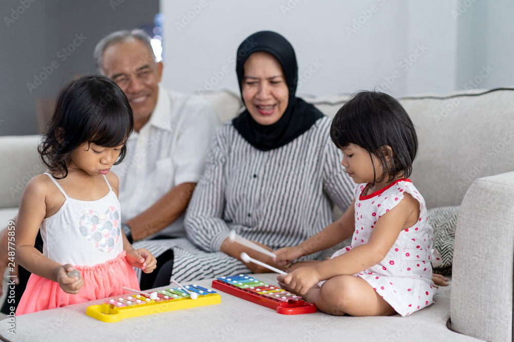 portrait of beautiful asian grandparent with their granddaughters in living room playing together portrait of beautiful asian grandparent with their granddaughters in living room playing together