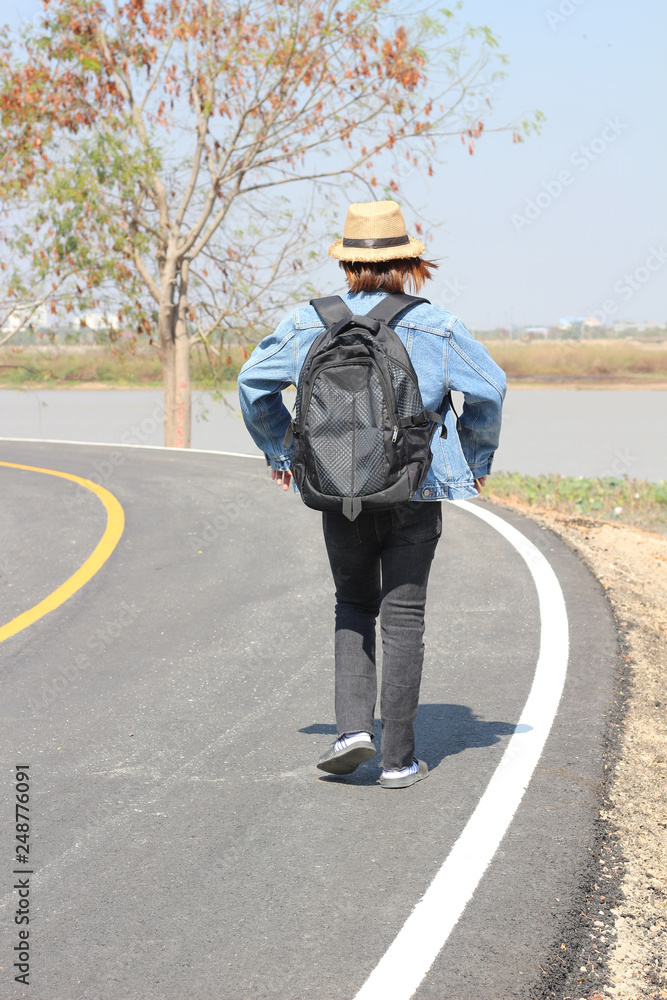 Girl in hat with backpack traveling on road, Travel concept. Girl in hat with backpack traveling on road, Travel concept.