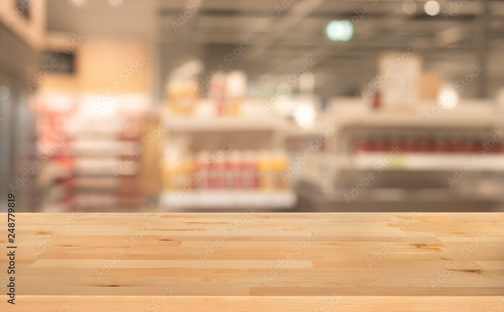 Wood table top on blur of supermarket product shelf background