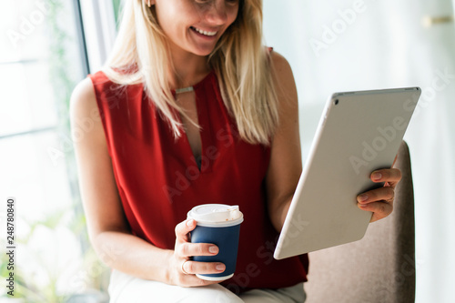 Canvas Print Businesswoman reading thew news from a digital tablet