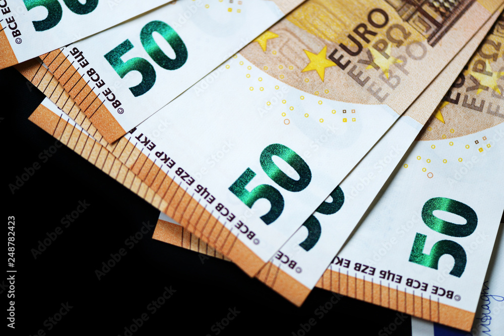 Fifty euro banknotes on a dark background close up Fifty euro banknotes on a dark background close up