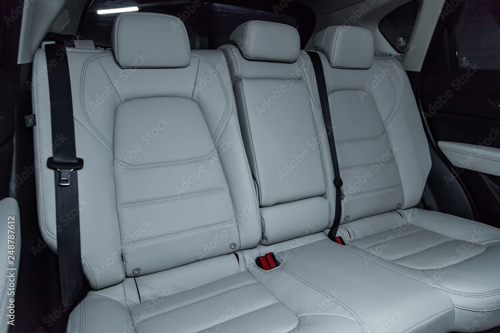 Fototapeta premium Сlose-up of the car interior: white leather rear seats and seat belts .