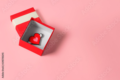 Нeart in a red gift box on a pastel pink background. February 14 card, Valentine's day. 8 March, International Happy Women's Day. Flat lay, top view, copy space  photo