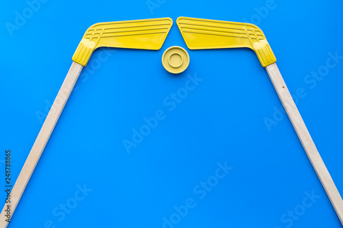 Ice hockey stick and puck on blue background top view copy space photo