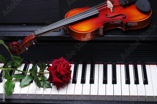 Schilderij op canvas Red rose and violin on piano keyboard