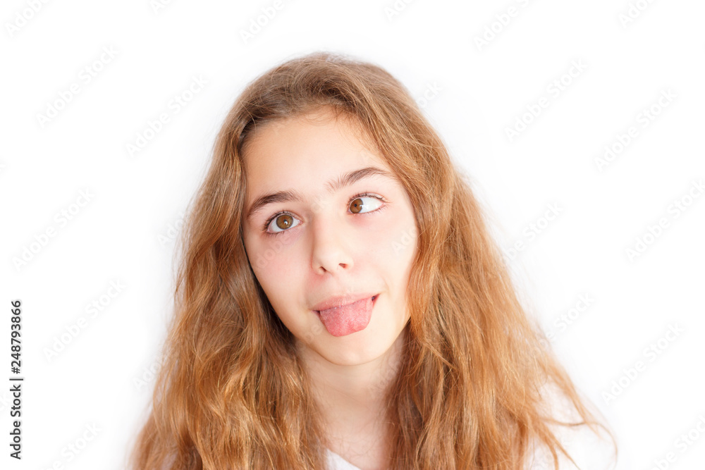 Pretty teenager girl with long hair makes very funny face and slanting eyes