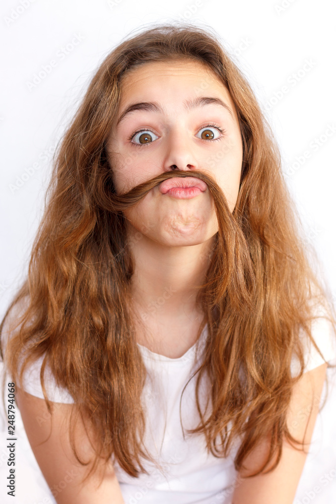 Teen girl fooling around and making a mustache out of her hair Teen girl fooling around and making a mustache out of her hair