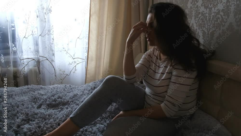 Depressed woman in bed. girl crying on the couch. Quarrel with your loved one on the phone. acute mountain Depressed woman in bed. girl crying on the couch. Quarrel with your loved one on the phone. acute mountain