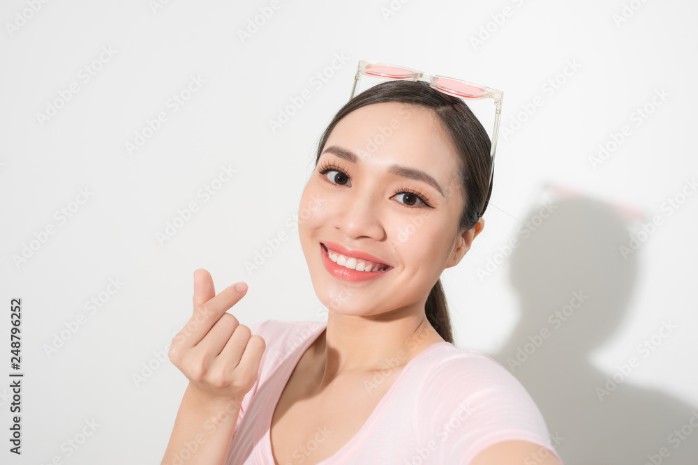 Studio portrait of beautiful woman smiling with white teeth and making selfie, photographing herself over white background Studio portrait of beautiful woman smiling with white teeth and making selfie, photographing herself over white background