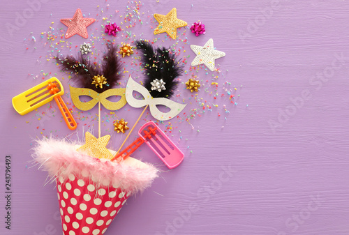 Purim celebration concept (jewish carnival holiday) over wooden purple background © tomertu