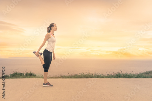 Female runner stretching before morning run. © kieferpix