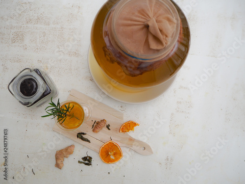 Glass with citrus, genger and rosemary flavored kombucha tea on a white background photo