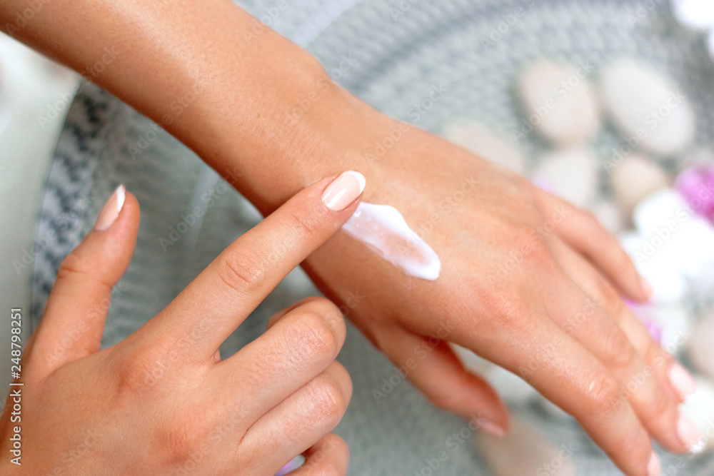 Fototapeta premium Skin Care Concept. Sp. Beautiful Woman With Hand Cream, Lotion On Her Hands. Closeup With Natural Manicure Applying Cosmetic Cream On Soft Skin. Beauty Concept